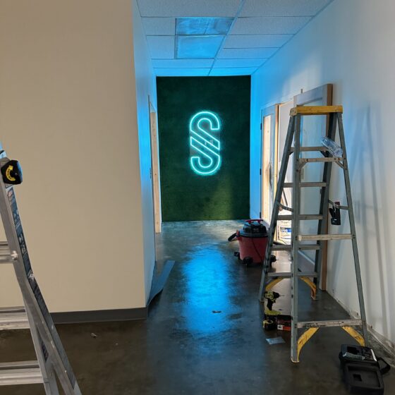 Hallway with a neon logo sign in the Miramar gym tenant improvement