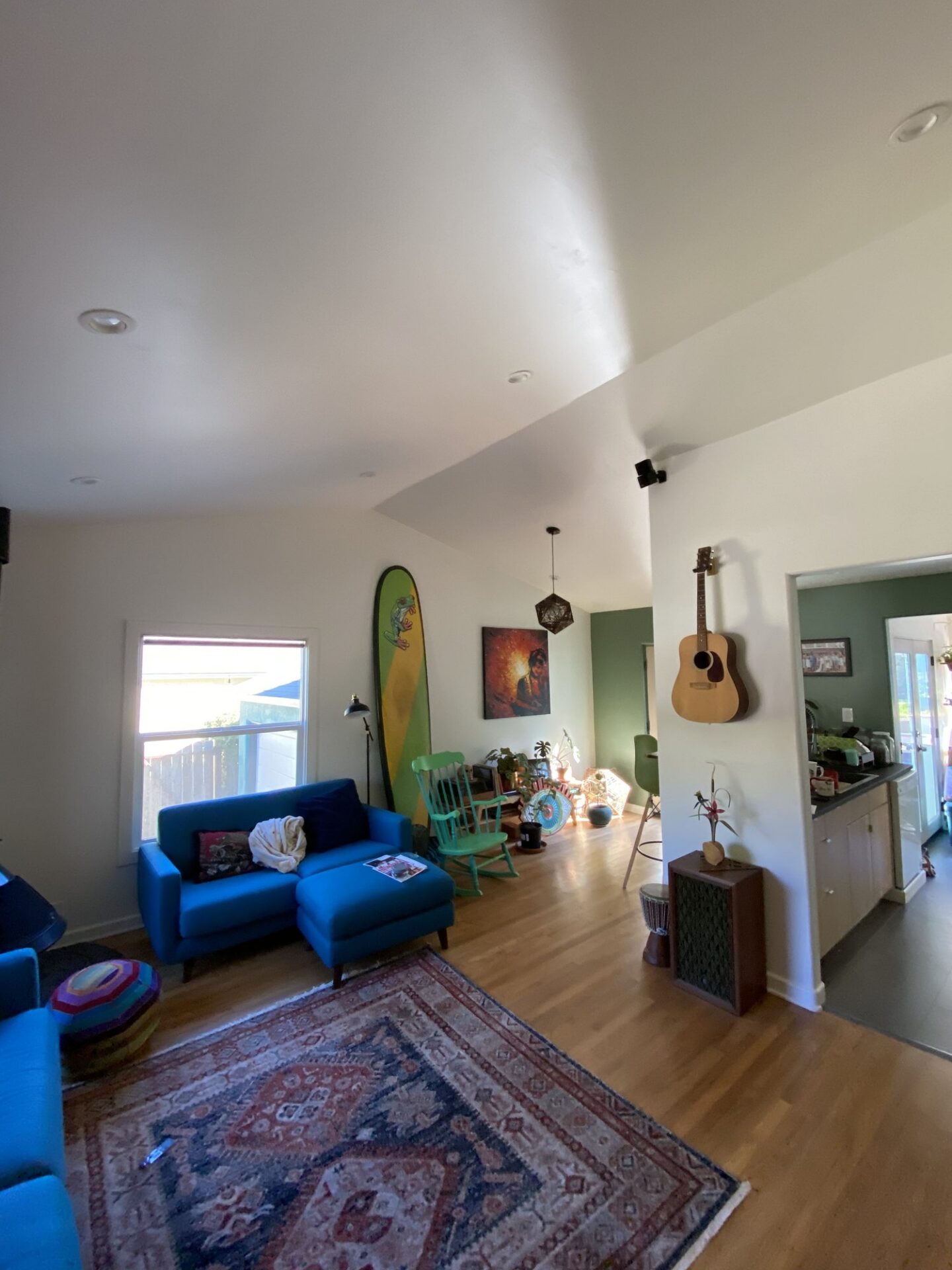 Point Loma living room after a ceiling vault, with a high white vaulted ceiling and hardwood floors