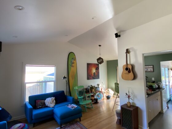 Point Loma living room after a ceiling vault, with a high white vaulted ceiling and hardwood floors