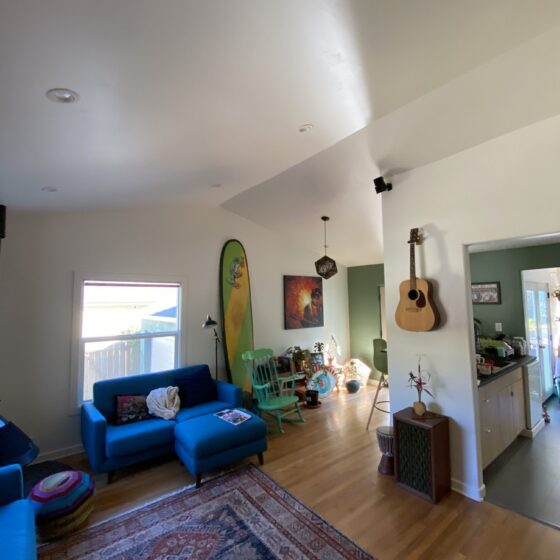 Point Loma living room after a ceiling vault, with a high white vaulted ceiling and hardwood floors