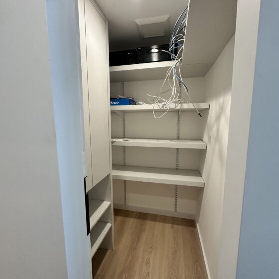 Media closet with white shelving in a Scripps Ranch home addition