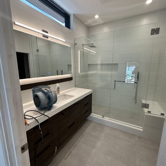 Bathroom with a dark wood vanity, frameless glass shower and clerestory window in a Scripps Ranch addition