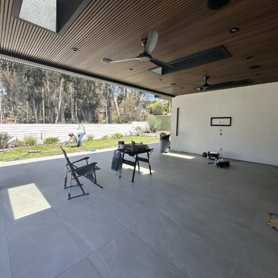 Covered patio with a NewTechWood composite slat ceiling, skylights and built-in speakers off a Scripps Ranch addition