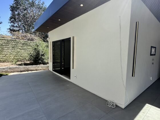 Scripps Ranch home addition with a covered patio, NewTechWood composite slat ceiling with skylights, and large-format tile