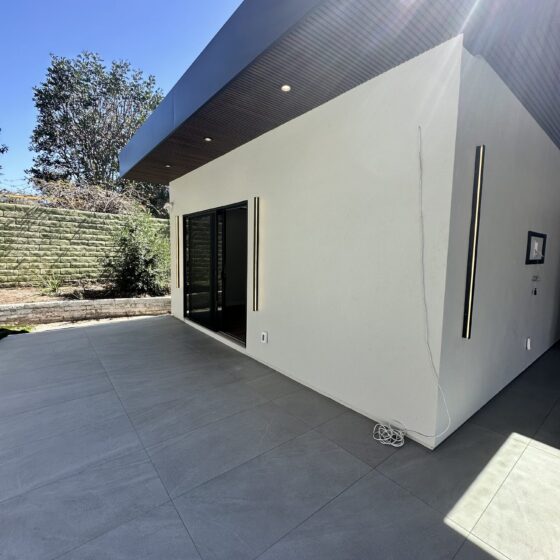 Scripps Ranch home addition with a covered patio, NewTechWood composite slat ceiling with skylights, and large-format tile
